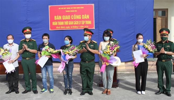 Trong ảnh: Đại diện Trung đoàn 855 trao giấy chứng nhận hoàn thành cách ly cho các công dân. Ảnh: Hải Yến-TTXVN