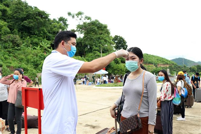 Trong ảnh: Lực lượng chức năng kiểm tra thân nhiệt lưu học sinh Lào tại cửa khẩu Chiềng Khương, tỉnh Sơn La. Ảnh: Hữu Quyết - TTXVN