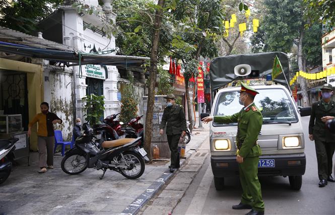  Lực lượng chức năng phường Hàng Mã, quận Hoàn Kiếm đề nghị các hộ kinh doanh thực hiện nghiêm quyết định của Ban chỉ đạo phòng, chống dịch COVID-19 TP Hà Nội. Ảnh: Doãn Tấn - TTXVN