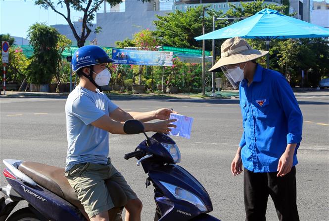 Người dân xuất trình giấy đi xét nghiệm COVID-19 tại các chốt kiểm tra phòng dịch trên đường. Ảnh: Trần Lê Lâm – TTXVN